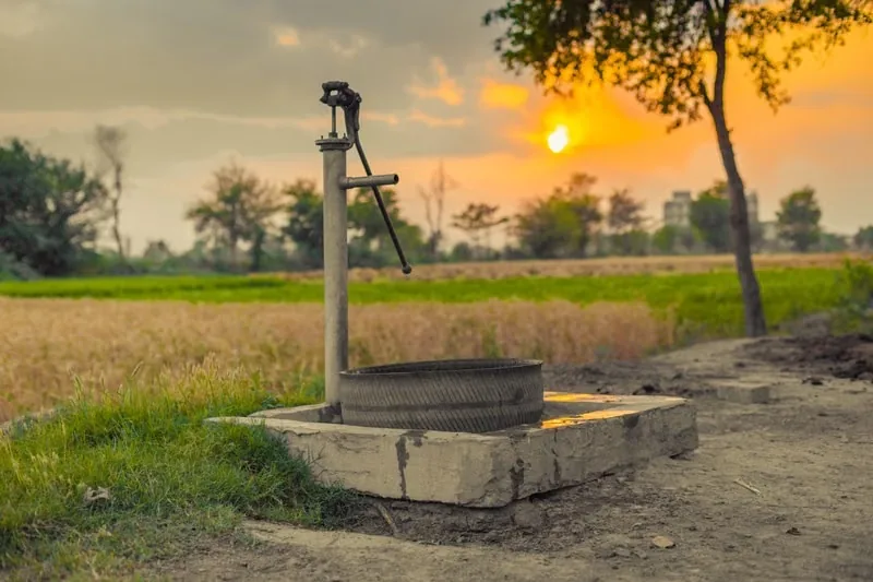 Rural water well pump in an agricultural landscape